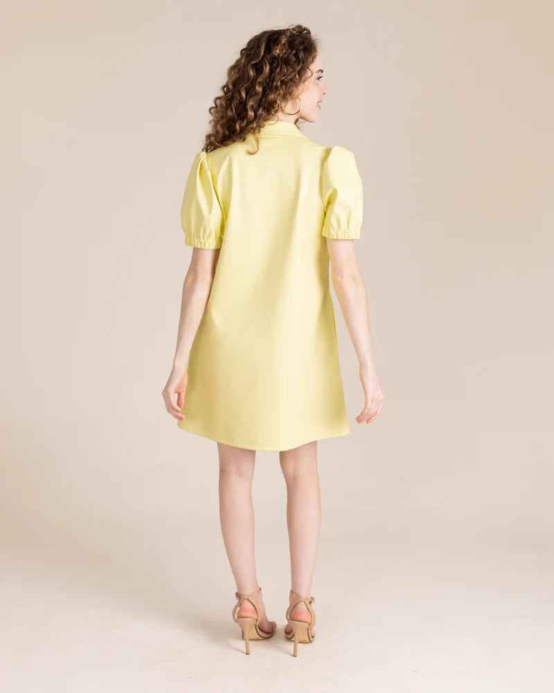 Woman's back in faux leather yellow dress
