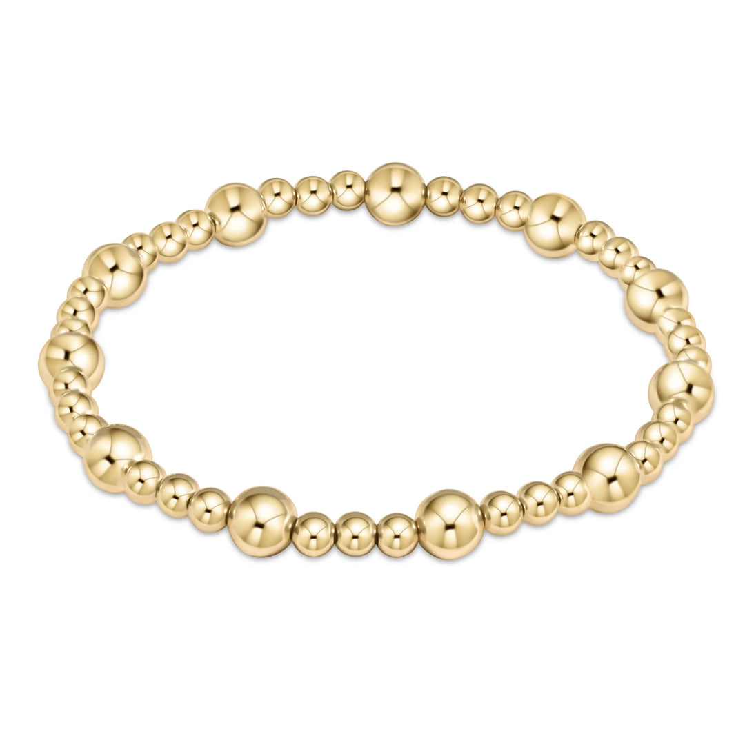 A gold bead bracelet with alternating larger and smaller bead sizes, hand beaded on high performance elastic.