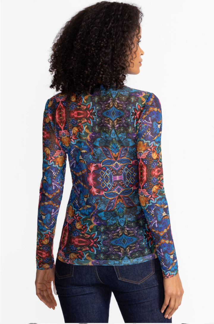 Woman wearing a colorful patterned long-sleeve top on a white background