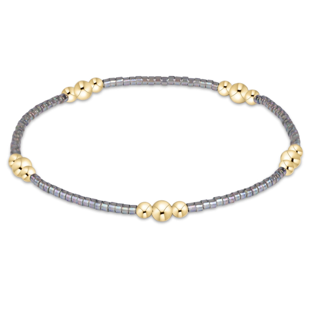 Enewton Hope Purpose Gold Bracelet 26FW, a stylish accessory with a sleek gold design, displayed on a neutral background.