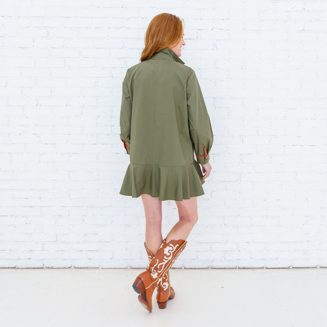 Caryn Lawn Eliza Dress hanging on a wooden hanger, showcasing its flowing fabric and elegant design.