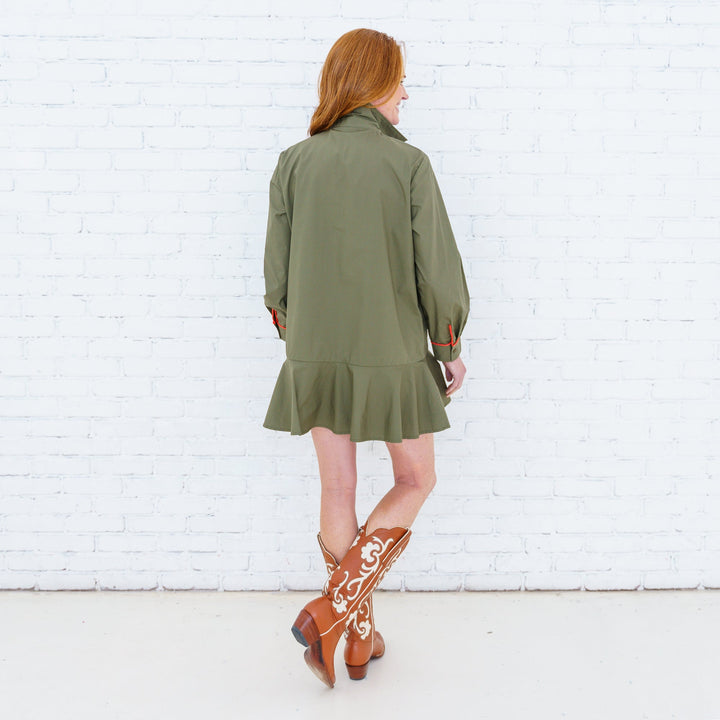 Caryn Lawn Eliza Dress hanging on a wooden hanger, showcasing its flowing fabric and elegant design.