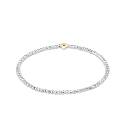 silver bracelet with gold bead on white background
