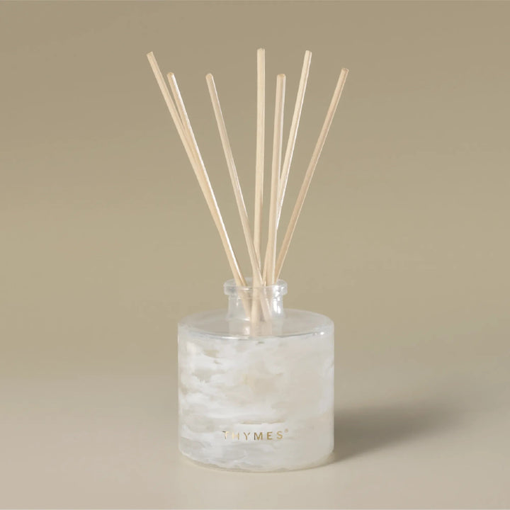 Thymes Tidings Petite Diffuser in a sleek, modern home decor setting with a glass bottle and reed sticks for aromatic diffusion