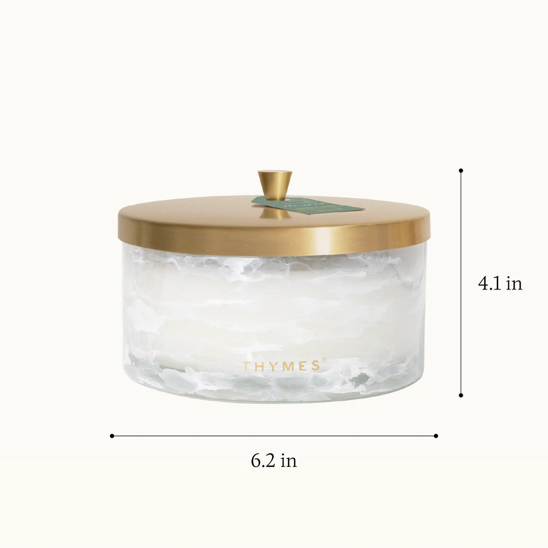 Thymes Tidings 4-wick candle in a decorative glass jar, perfect for home decor and creating a warm, festive ambiance.