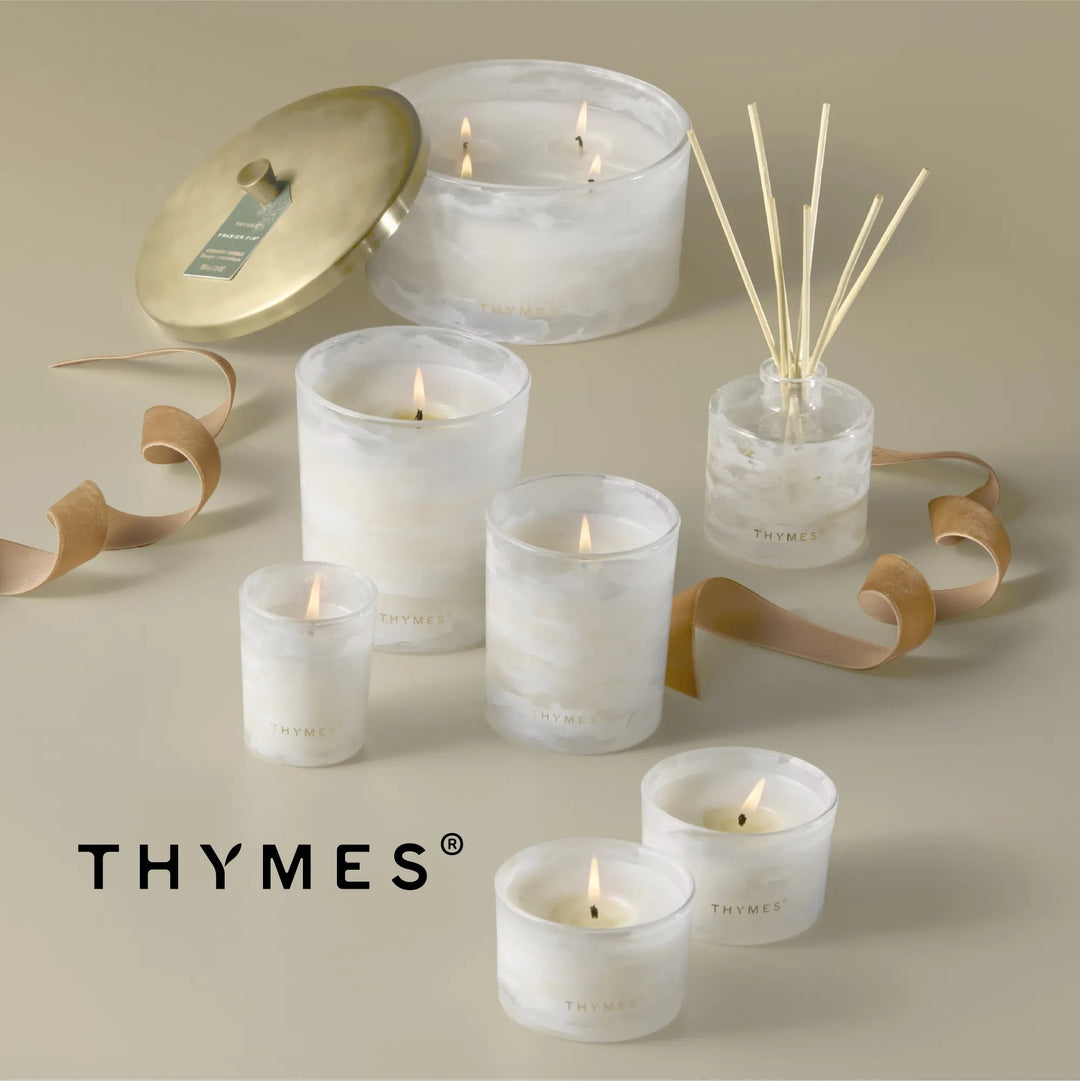 Thymes Tidings 4-wick candle in a decorative jar, designed for home ambiance and cozy decor.