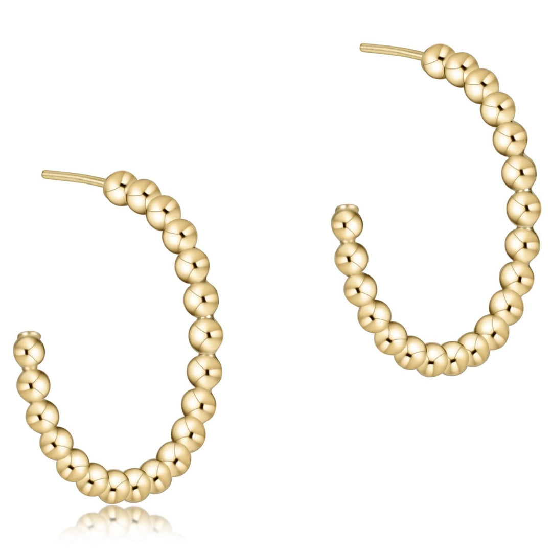 Gold beaded hoop earrings on a white background