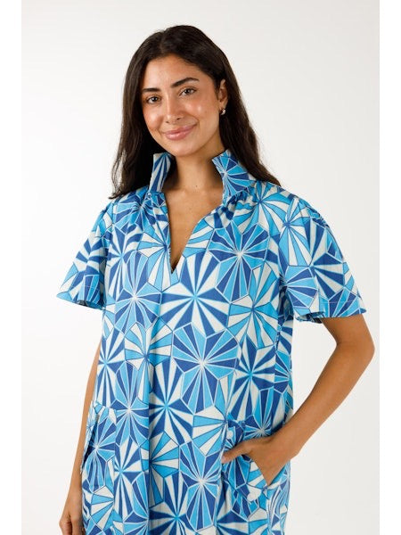 Woman wearing a blue and white patterned dress on a white background