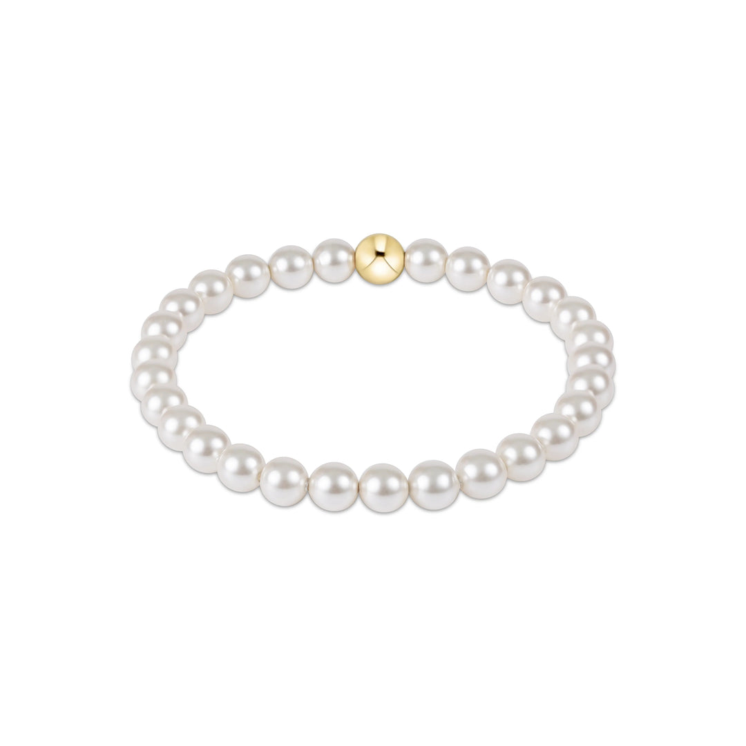 Pearl bracelet with a gold bead on a white background
