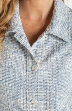 Close-up of a person wearing a textured blue shirt with a collar.