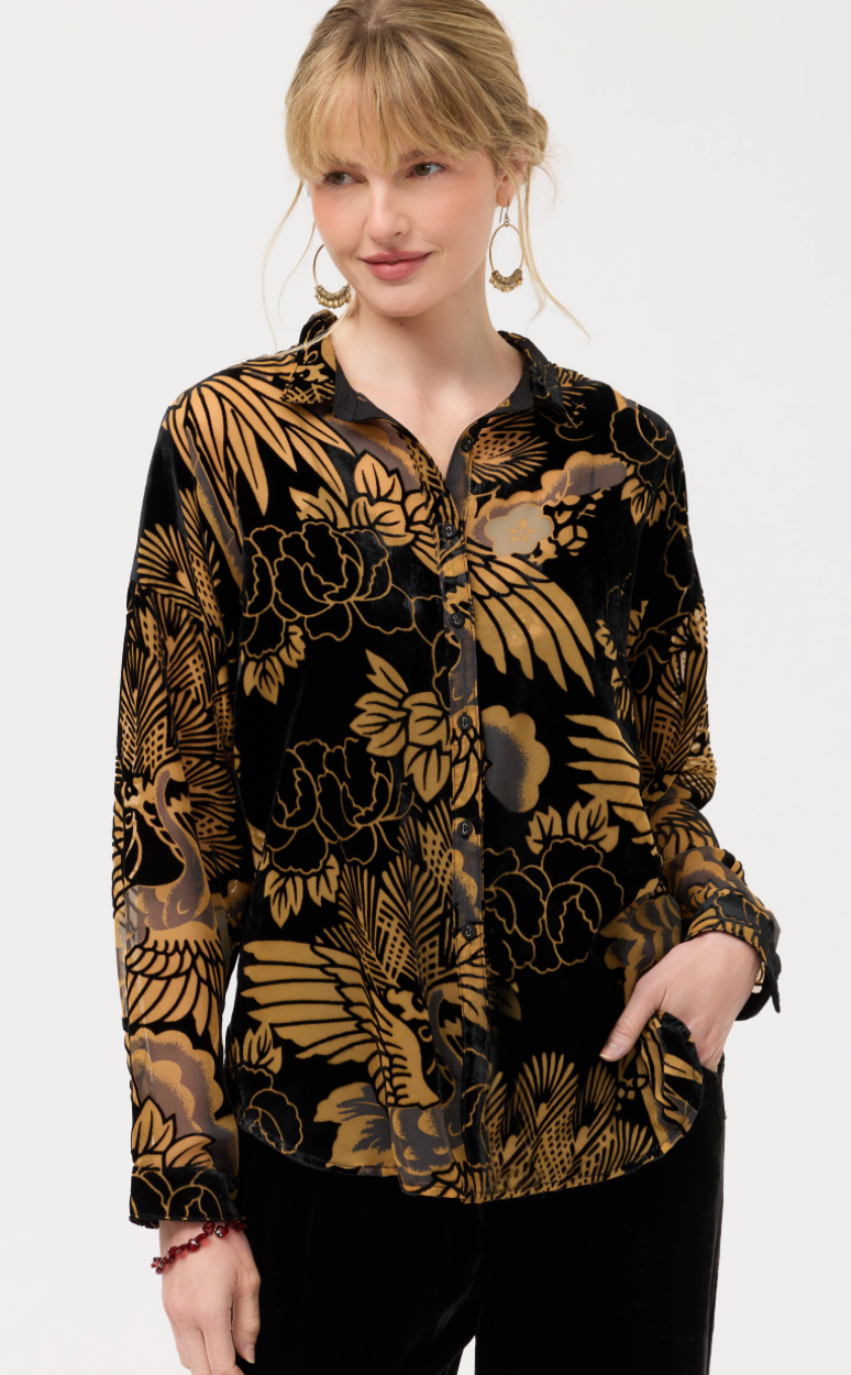 Woman wearing a black floral patterned blouse on a white background