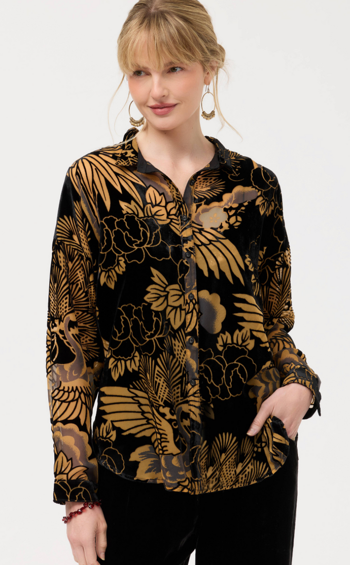 Woman wearing a black floral patterned blouse on a white background
