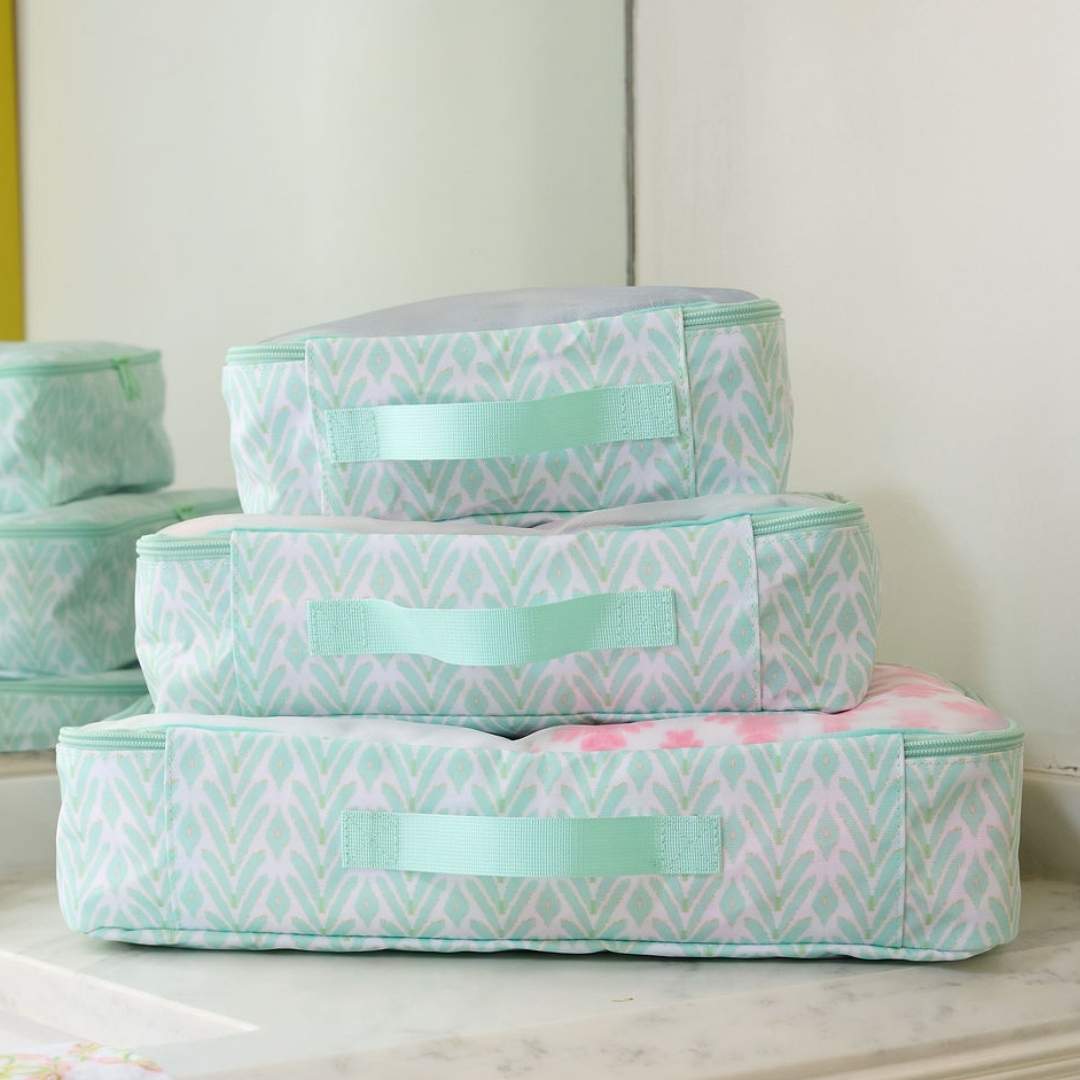 Mint Laura Park Designs packing cubes set, compact travel organizers with multiple compartments for efficient packing.