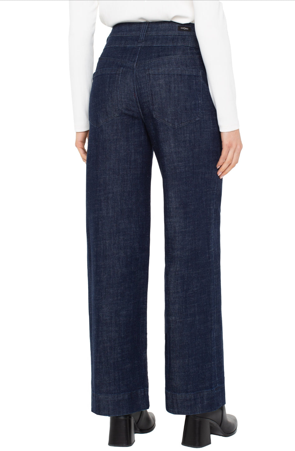 Dark blue jeans worn by a person on a white background