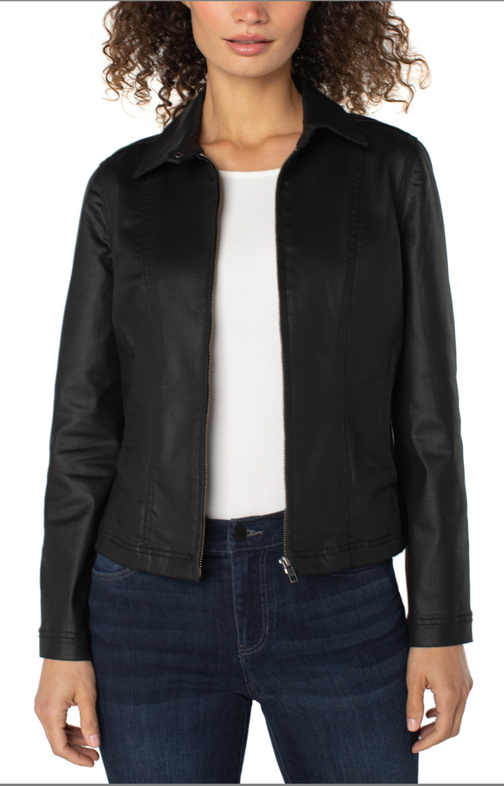 Person wearing a black leather jacket over a white shirt and dark jeans on a white background