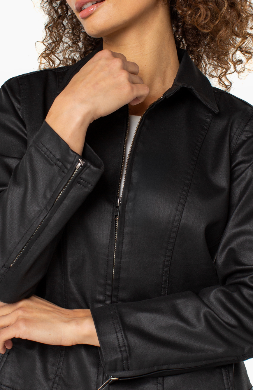 Person wearing a black jacket with a neutral background