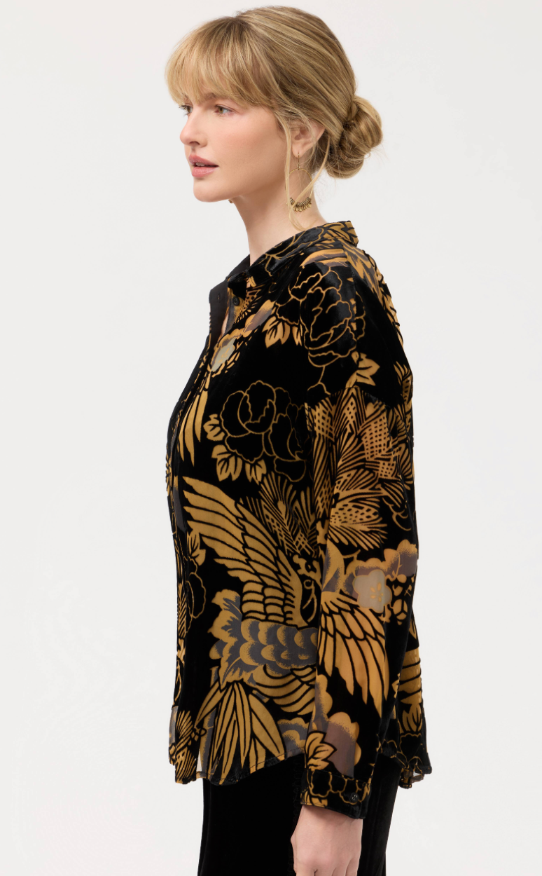 Woman wearing a black floral patterned blouse on a white background