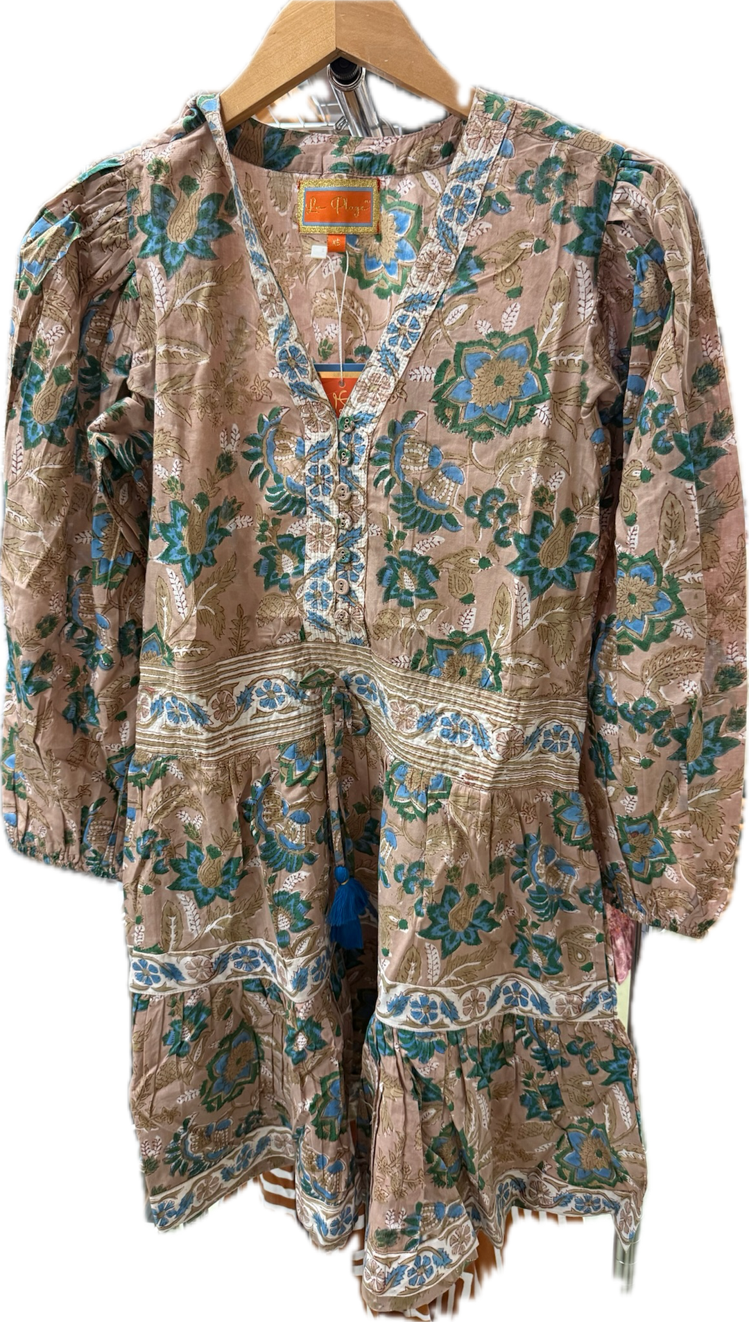 La Plage Melissa Bellevue Blossom Dress displayed on a hanger, featuring a floral pattern and flowing fabric in a light, summery style.