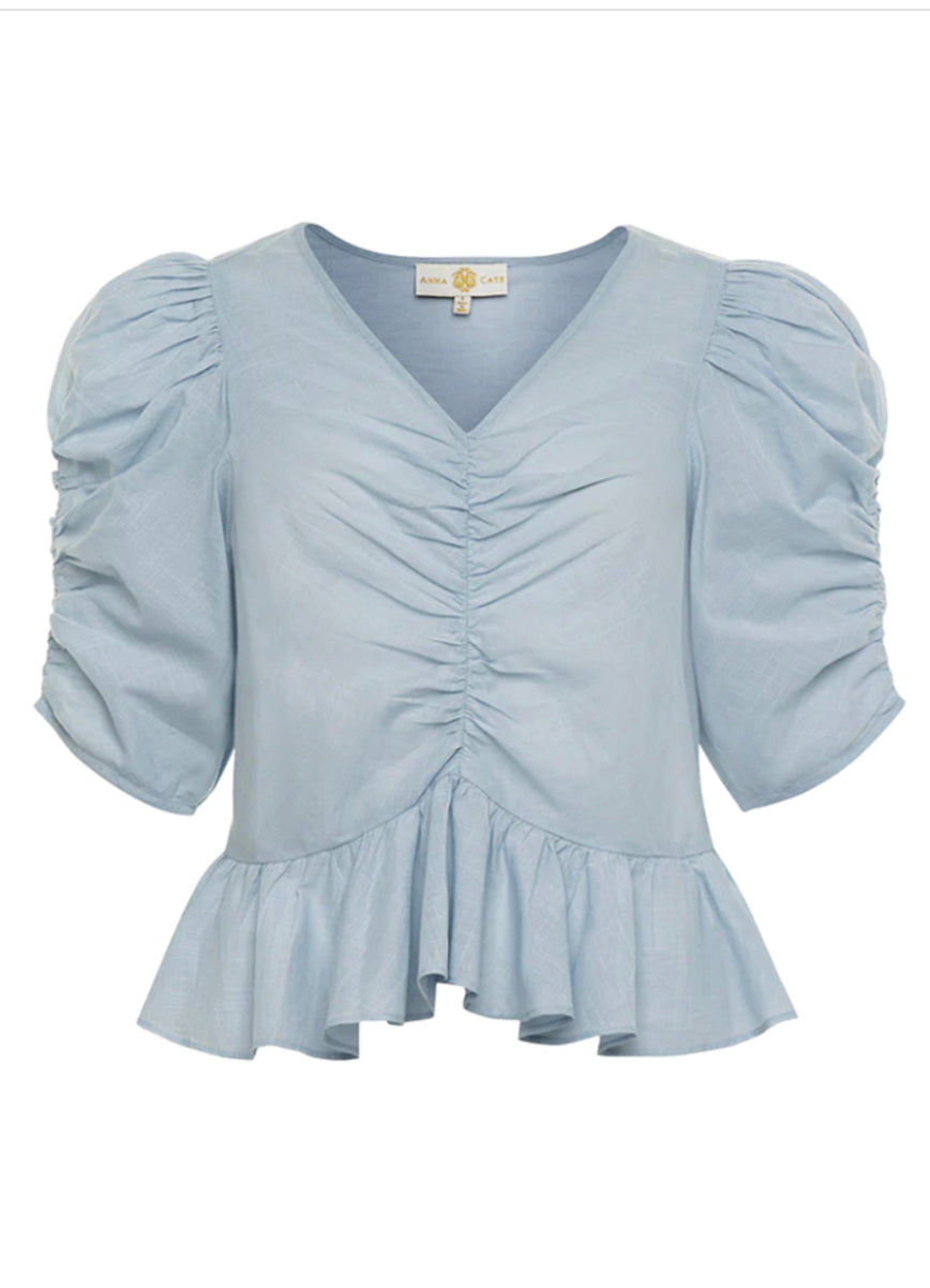 Anna Cate ruched top in soft fabric, featuring gathered details and a fitted silhouette, perfect for casual or dressy occasions.