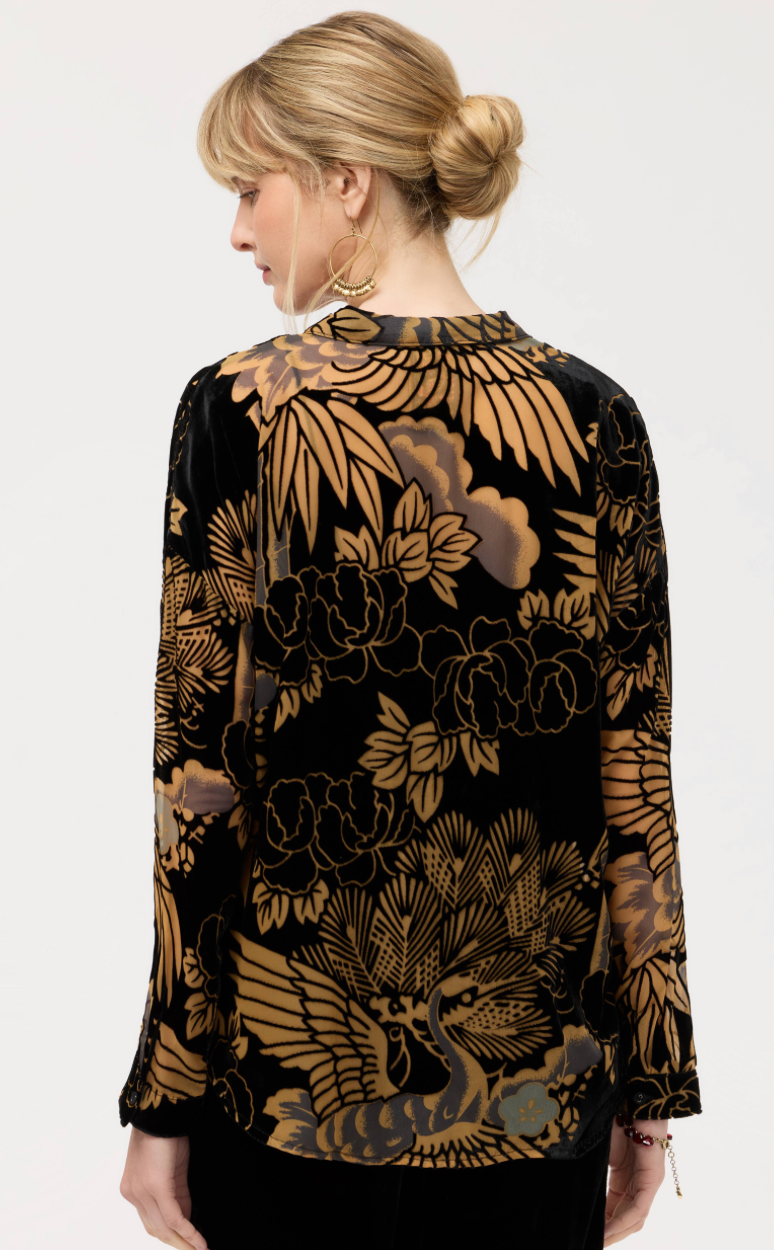Woman wearing a black floral patterned blouse on a white background