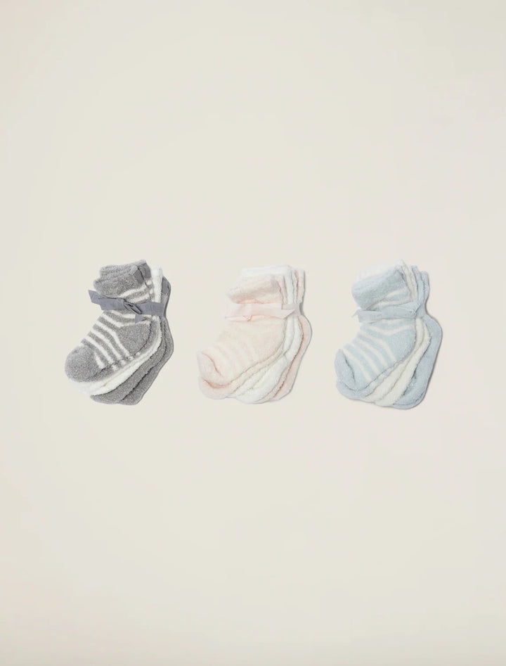 Set of three barefoot dreams infant socks in soft, colorful fabrics perfect for gift-giving and comfortable baby wear.