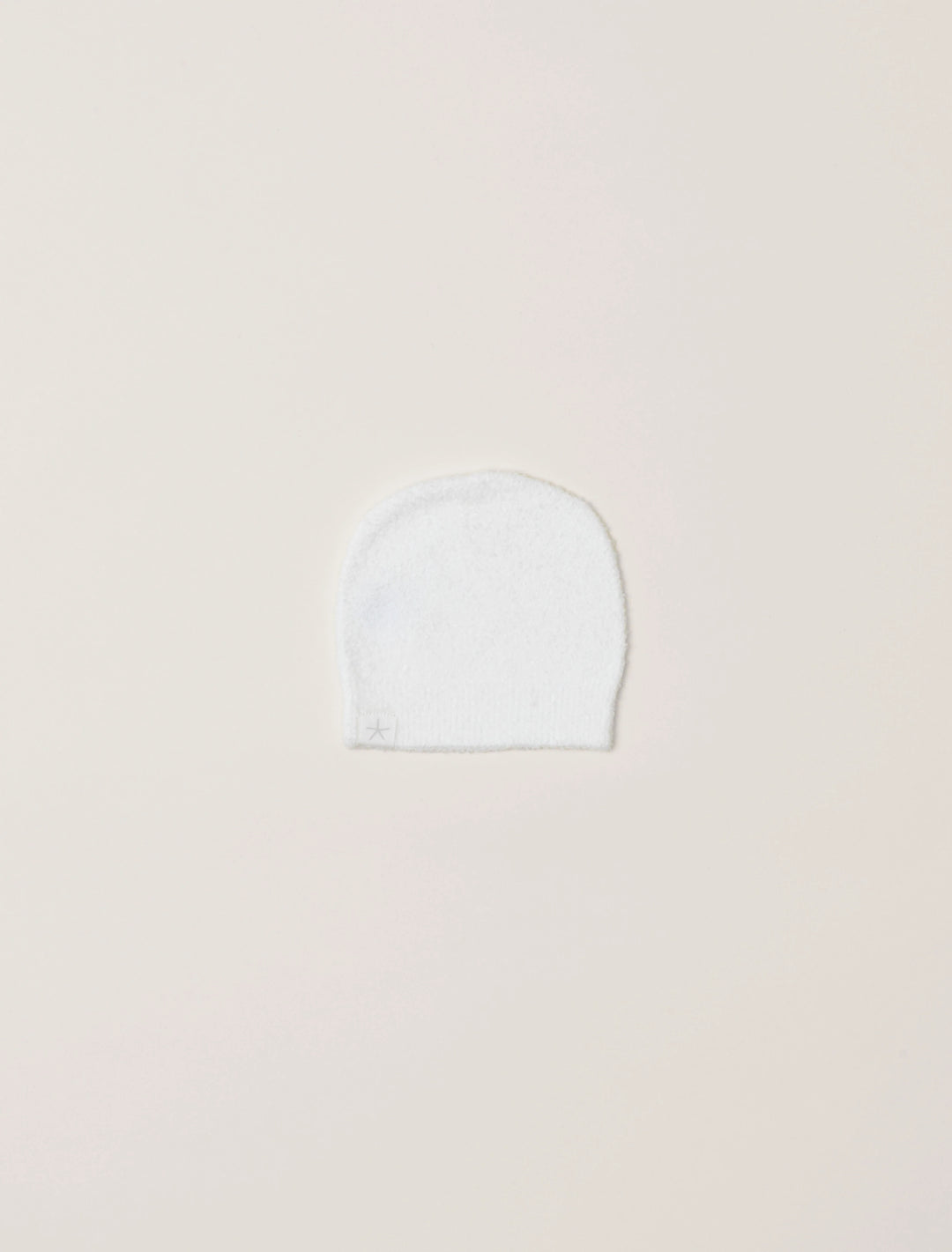 Soft beige barefoot dreams cozy infant beanie with ribbed knit texture, perfect for keeping babies warm and stylish.
