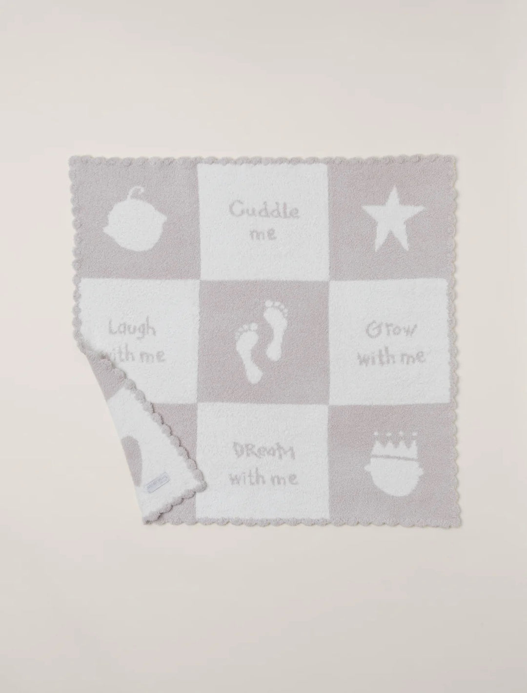 Barefoot Dreams cuddle receiving blanket, soft and cozy gift for babies, shown draped over a plush surface.