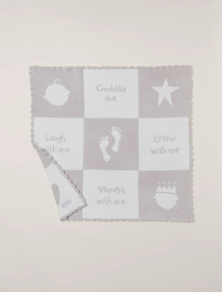 Barefoot Dreams cuddle receiving blanket, soft and cozy gift for babies, shown draped over a plush surface.