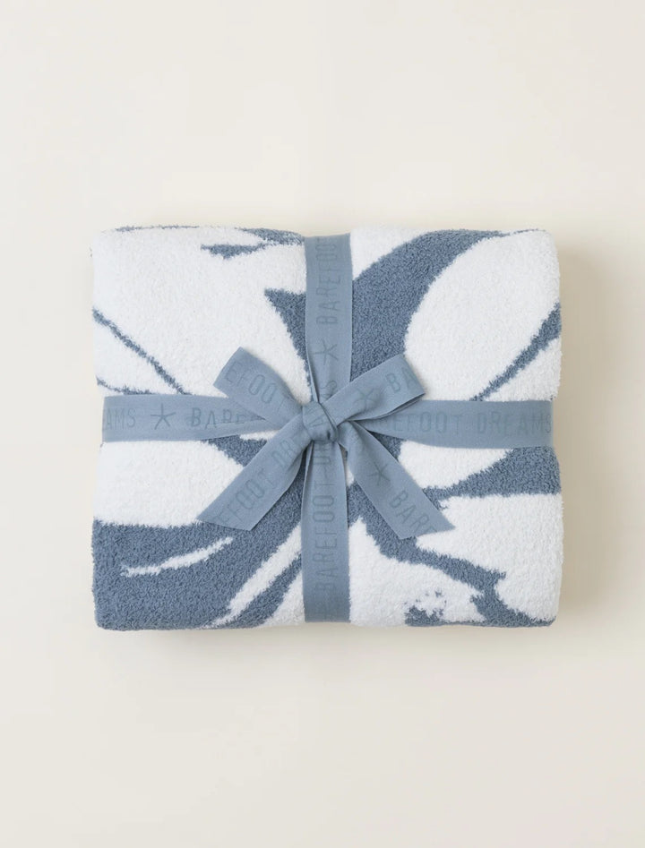 Soft Barefoot Dreams Cozy Petals blanket draped over a cozy sofa, showcasing its plush, floral-inspired design and luxurious texture.