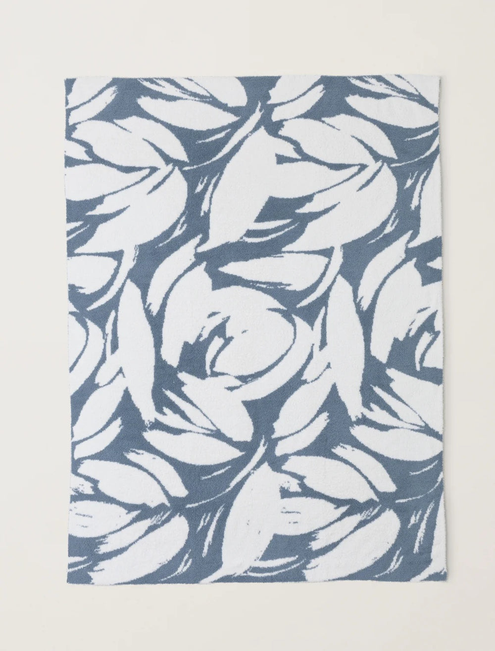 Barefoot Dreams Cozy Petals blanket draped over a sofa, soft plush fabric ideal for cozy home decor and comfort.