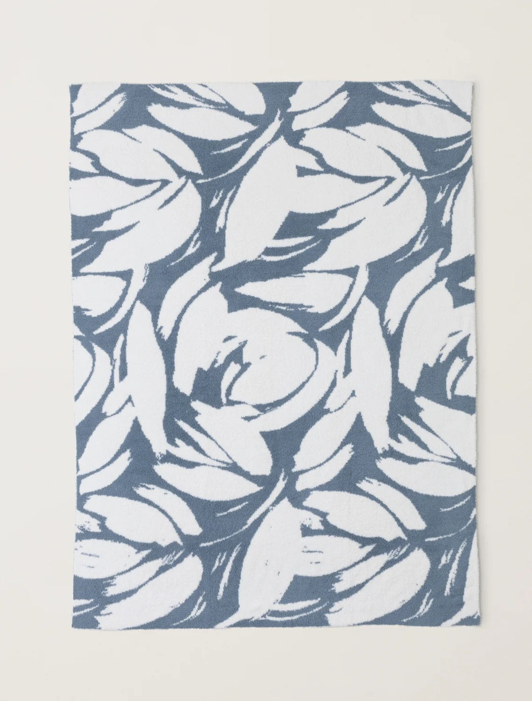 Barefoot Dreams Cozy Petals blanket draped over a sofa, soft plush fabric ideal for cozy home decor and comfort.