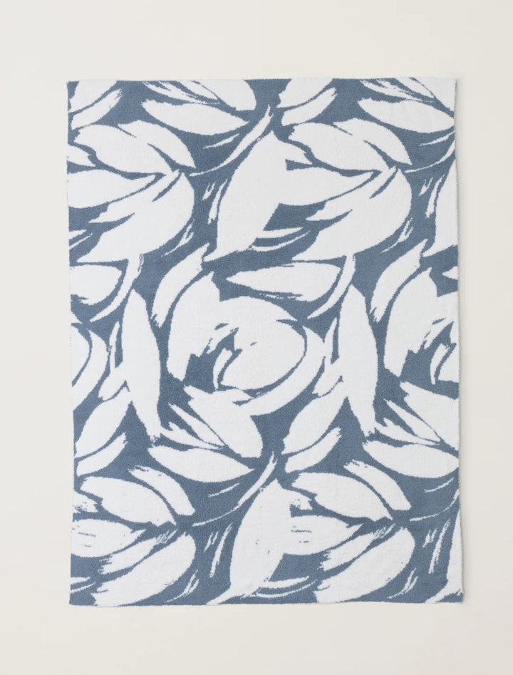 Barefoot Dreams Cozy Petals blanket draped over a sofa, soft plush fabric ideal for cozy home decor and comfort.