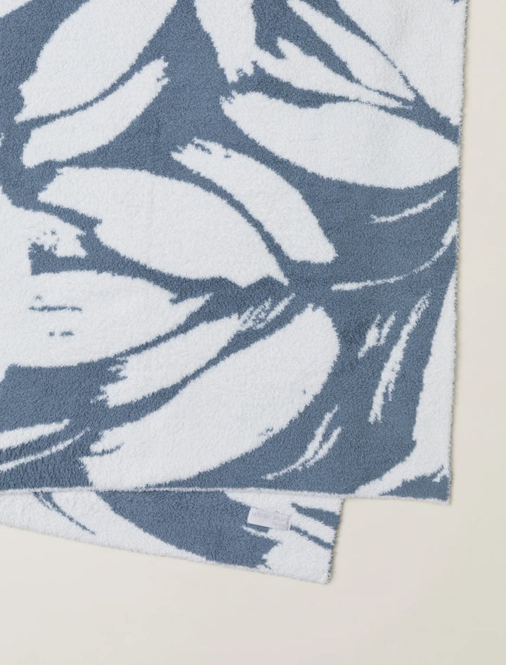 Barefoot Dreams Cozy Petals blanket in soft, plush fabric draped over a cozy armchair for home comfort.