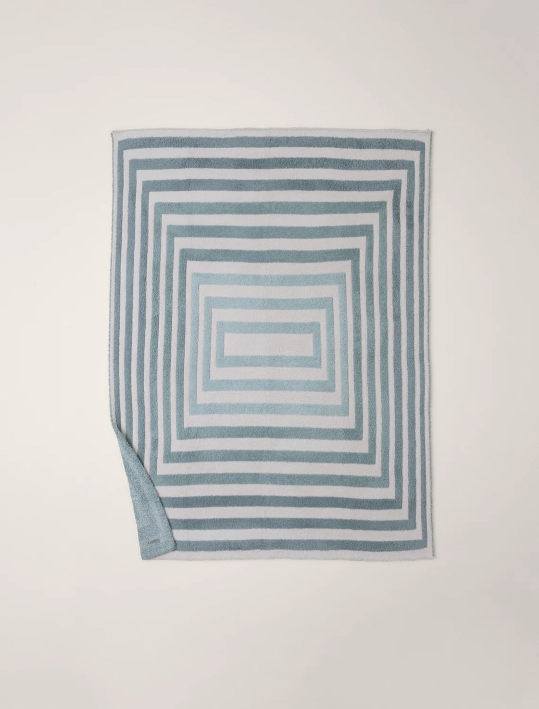 Barefoot Dreams Cozy Prismatic Throw blanket draped over a sofa, showcasing its soft, colorful, and plush fabric for home decor.