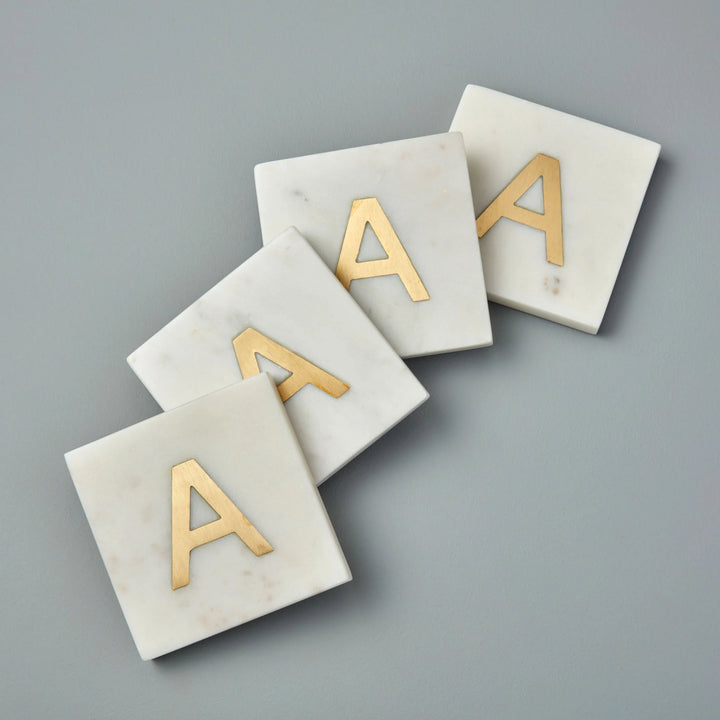 Marble and gold inlay initial coaster set from Be Home, showcasing elegant home decor with stylish marble and gold accents.