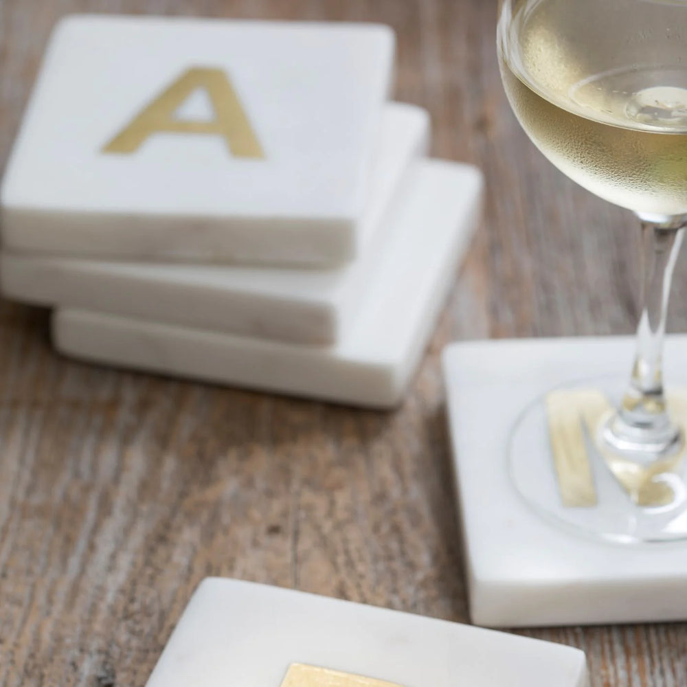 Marble and gold inlay initial coaster set for home decor, featuring elegant marble surfaces with gold accents and personalized initials.