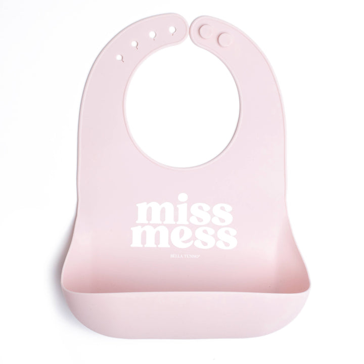 Baby wearing Bella Tunno Miss Mess Wonder Bib, waterproof and adjustable baby bib with colorful patterns for feeding and messy play.