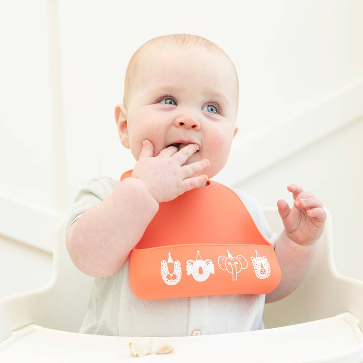 Baby Bella Tunno Party Animals Starter Bib with colorful animal designs, soft fabric, and adjustable neck strap for infants.