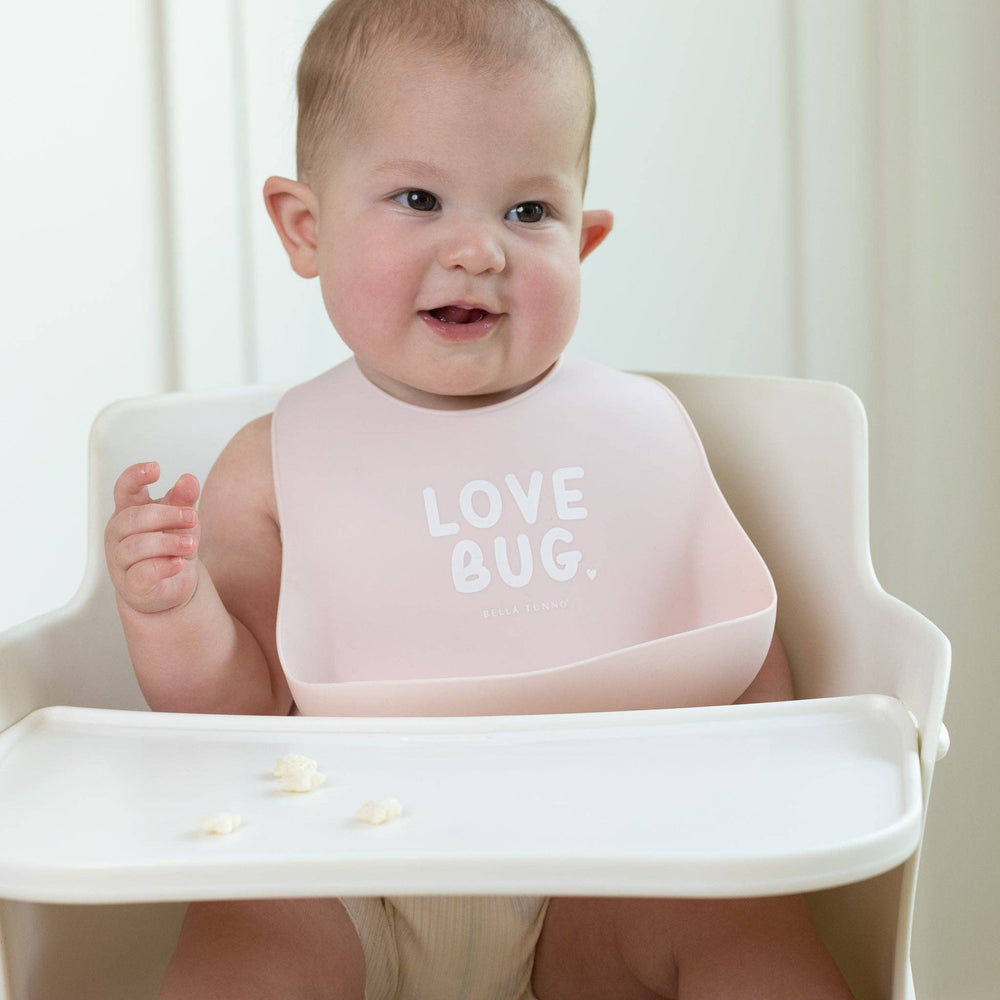 Baby wearing the Love Bug Wonder Bib by Bella Tunno, showcasing a colorful, soft baby bib with playful bug design.