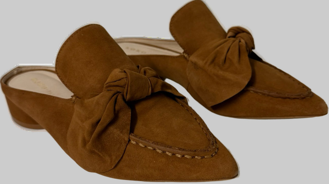 Brown suede mules with bow details on a white background