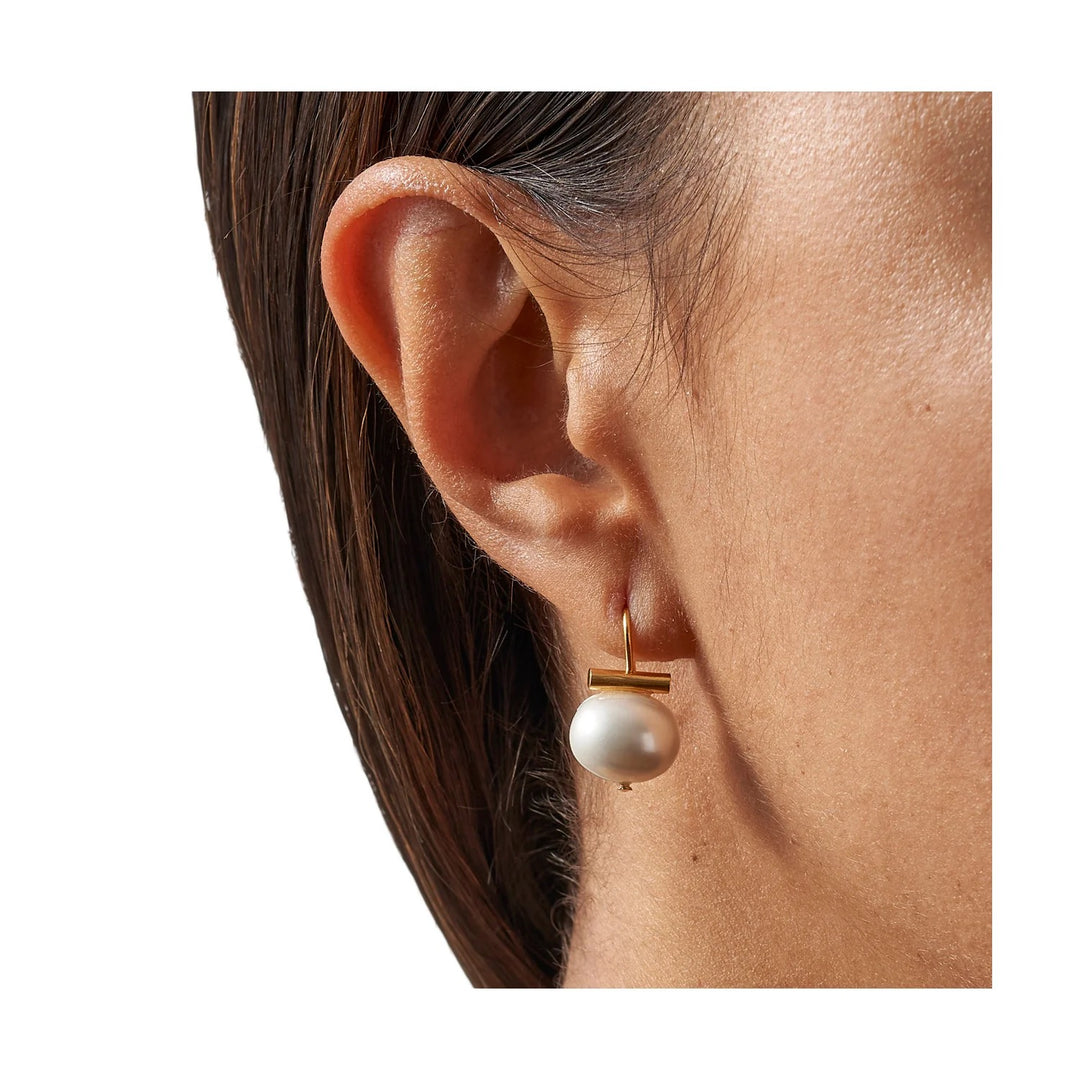 Pearl Petite Pebble earring by Catherine Canino featuring a small, smooth pearl in a minimalist jewelry accessory.