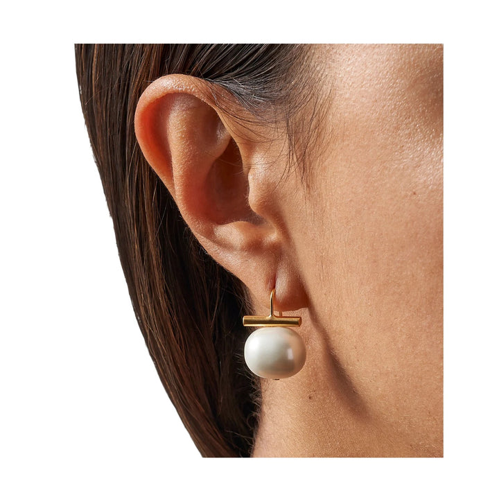 Catherine Canino Pebble Medium Pearl Earrings, elegant accessories with round pearls and silver hooks, close-up view.