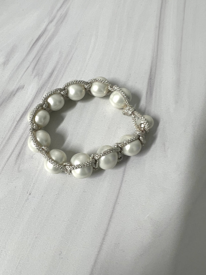 Pearl macrame bracelet with button clasp, handmade jewelry by Catherine Canino, featuring white pearls and intricate knot details.