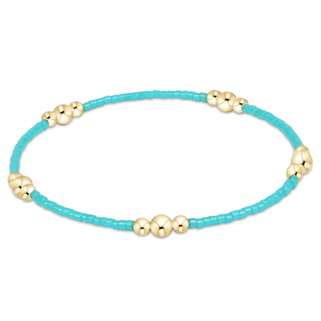 Enewton Hope Purpose Gold Bracelet with turquoise beads, gold chain, and charm, styled as a beautiful accessories piece