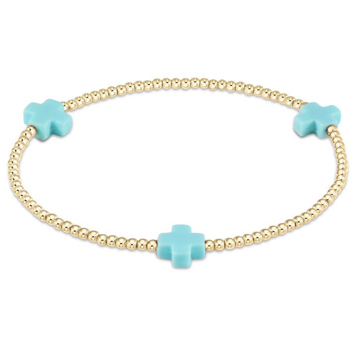 Enewton Signature Cross 2mm gold bracelet with delicate chain and small cross charm, stylish accessory for everyday wear.