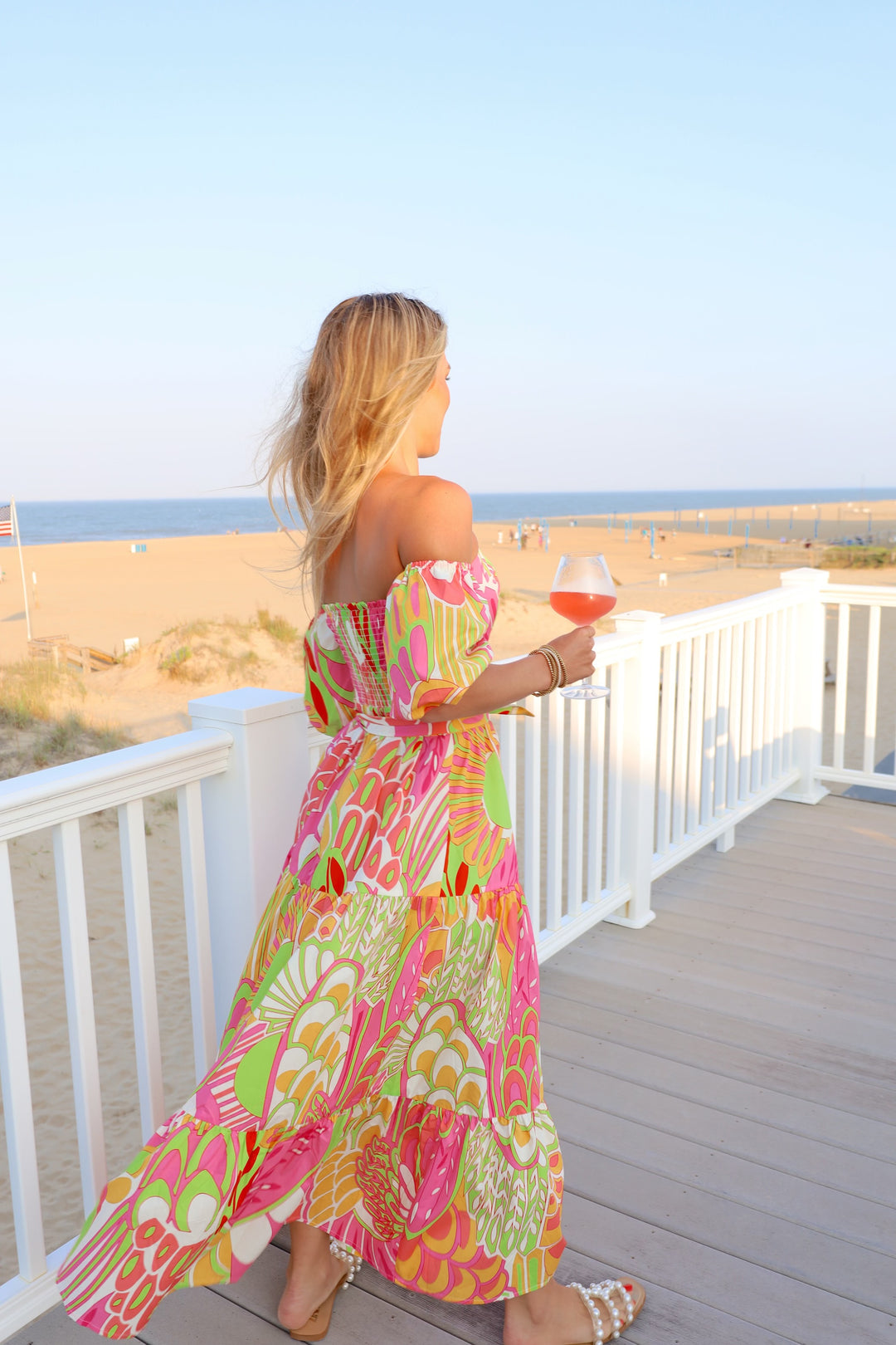 Flora Bea Oly Dress displayed on model with floral pattern and flowing fabric, perfect for casual or semi-formal occasions.
