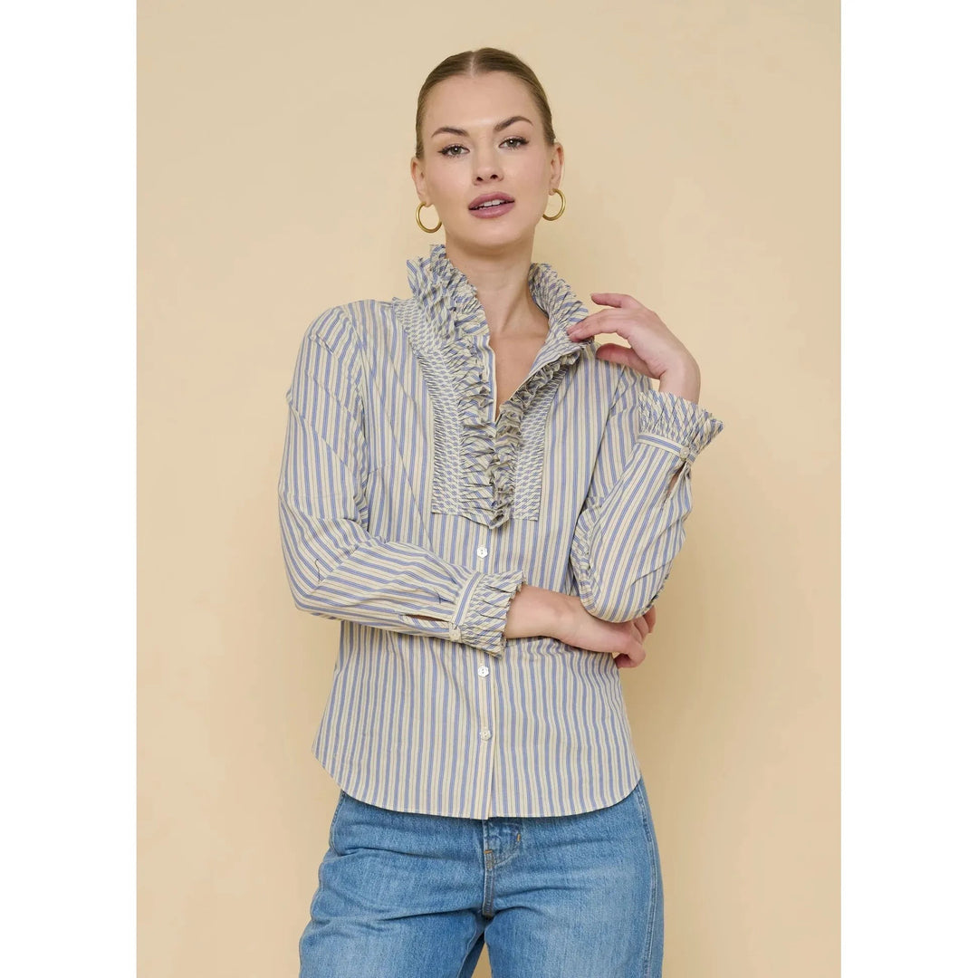 Flora Bea Indie Ruffle Blouse featuring feminine ruffles and lightweight fabric, displayed on a hanger against a neutral background.