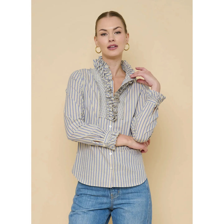 Flora Bea Indie Ruffle Blouse featuring feminine ruffles and lightweight fabric, displayed on a hanger against a neutral background.
