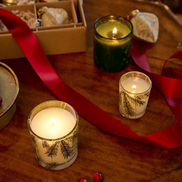 Frazier Fir Pine Needle Votive Candle by Thymes, showcasing a scented candle in a glass holder with pine needle design.