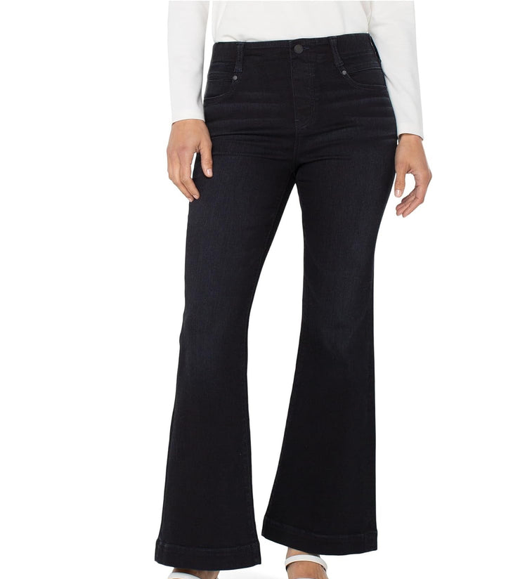 Black flared jeans worn by a person on a white background